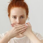 nő szájra tett kézzel