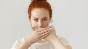 nő szájra tett kézzel