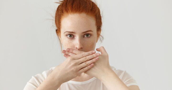 nő szájra tett kézzel